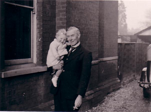 Francis Bergh holding baby near house